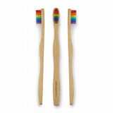 Minimalistische studiofoto van een bamboe tandenborstels met regenboogkleurige borstelharen. Gefotografeerd op een witte achtergrond met zachte professionele belichting en subtiele fotorealistische schaduwen voor een frisse, premium uitstraling