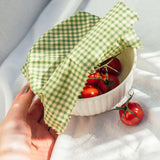 Plant Wax Food Wrap gebruikt om schaaltje met tomaten af te dekken met zachte natuurlijke belichting voor een frisse, duurzame en premium uitstraling